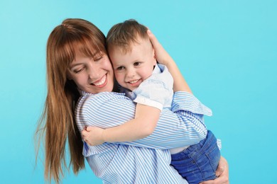 Photo of Mother and her cute son on light blue background