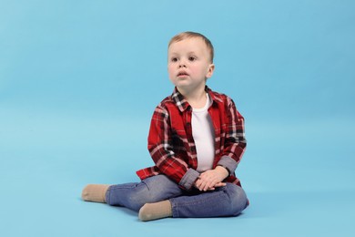 Photo of Cute little boy on light blue background