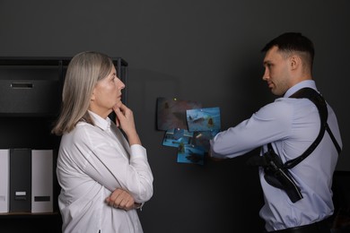 Forensic experts working with crime scene photos in office