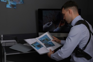 Forensic expert working with crime scene photos in office