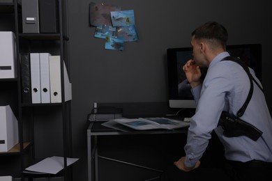 Forensic expert working with crime scene photos in office