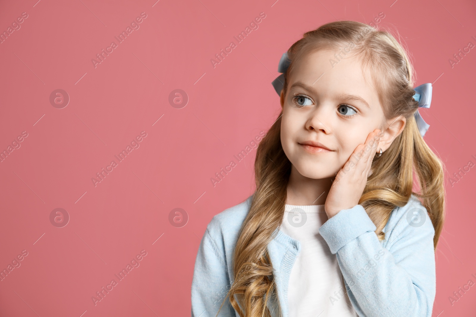 Photo of Cute little girl with beautiful hair accessory on coral background. Space for text