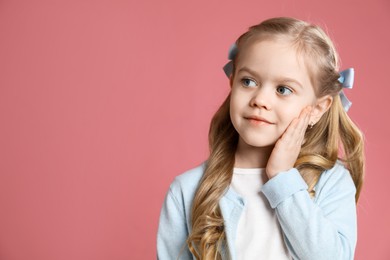 Photo of Cute little girl with beautiful hair accessory on coral background. Space for text