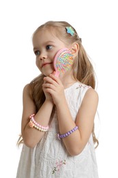 Photo of Cute little girl with beautiful hair clips and brush on white background