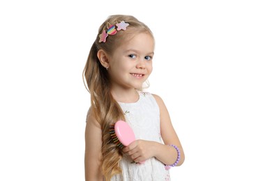 Photo of Cute little girl with beautiful hair clips and brush on white background