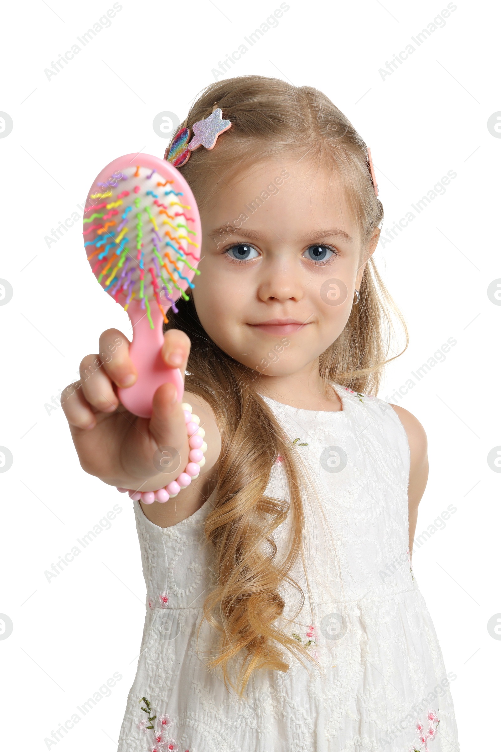 Photo of Cute little girl with beautiful hair clips and brush on white background