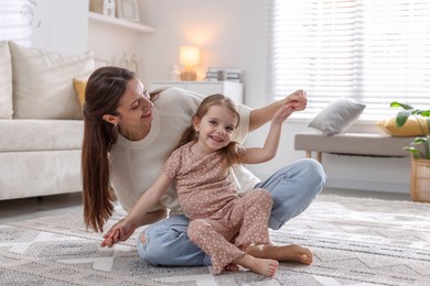 Photo of Happy mother having fun with her cute little daughter at home