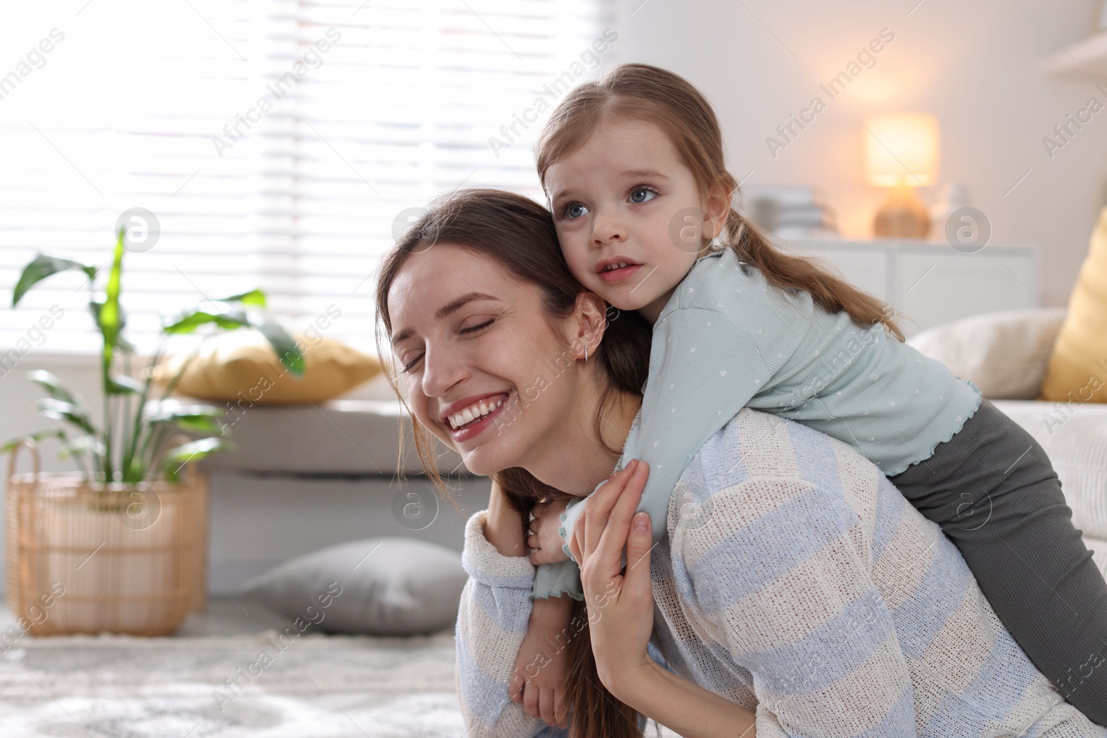 Photo of Happy mother having fun with her cute little daughter at home