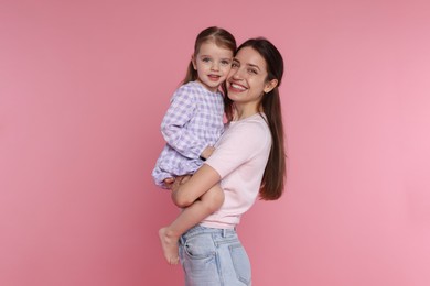 Photo of Portrait of happy mother with her cute little daughter on pink background