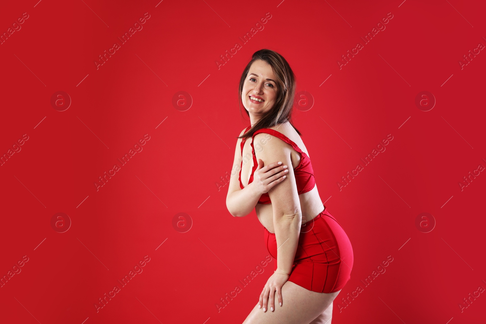 Photo of Woman in underwear on red background, space for text. Cellulite problem