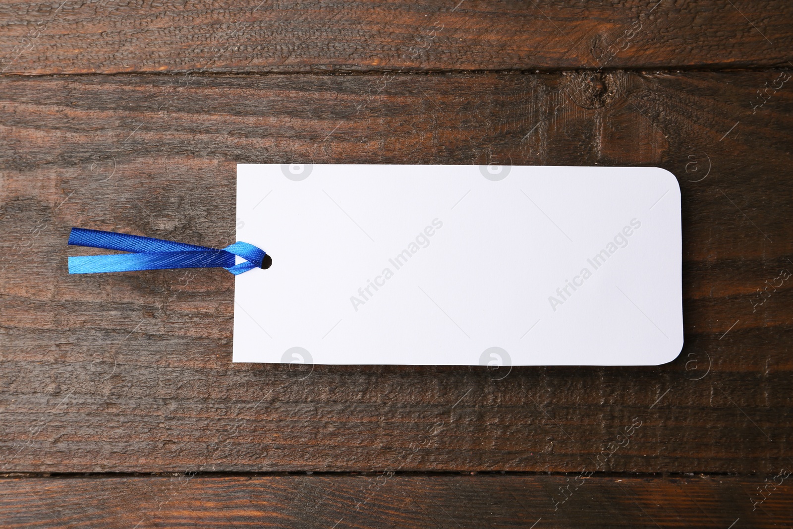 Photo of One paper bookmark on wooden background, top view