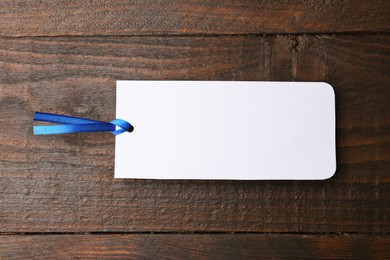 One paper bookmark on wooden background, top view