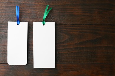 Photo of Paper bookmarks on wooden background, top view. Space for text