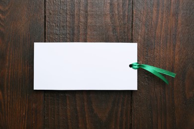 One paper bookmark on wooden background, top view