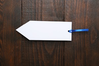 One paper bookmark on wooden background, top view