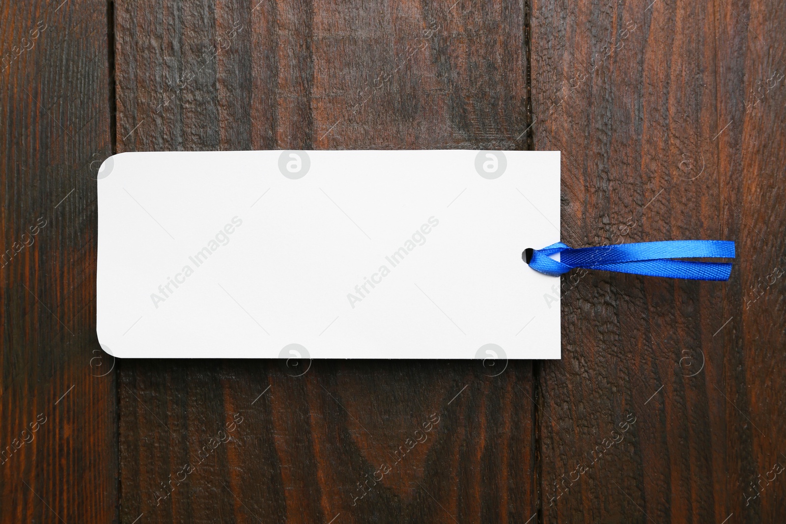 Photo of One paper bookmark on wooden background, top view