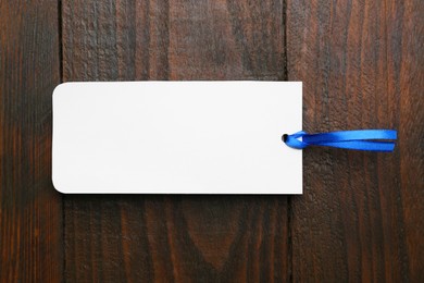 Photo of One paper bookmark on wooden background, top view