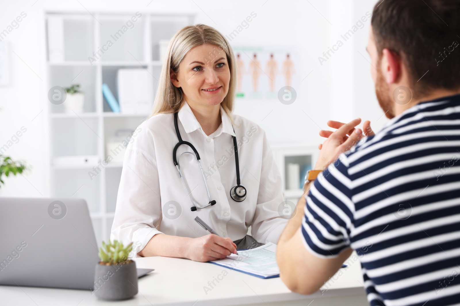 Photo of Doctor and her patient at desk in hospital