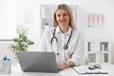 Photo of Professional doctor working on laptop at desk in hospital