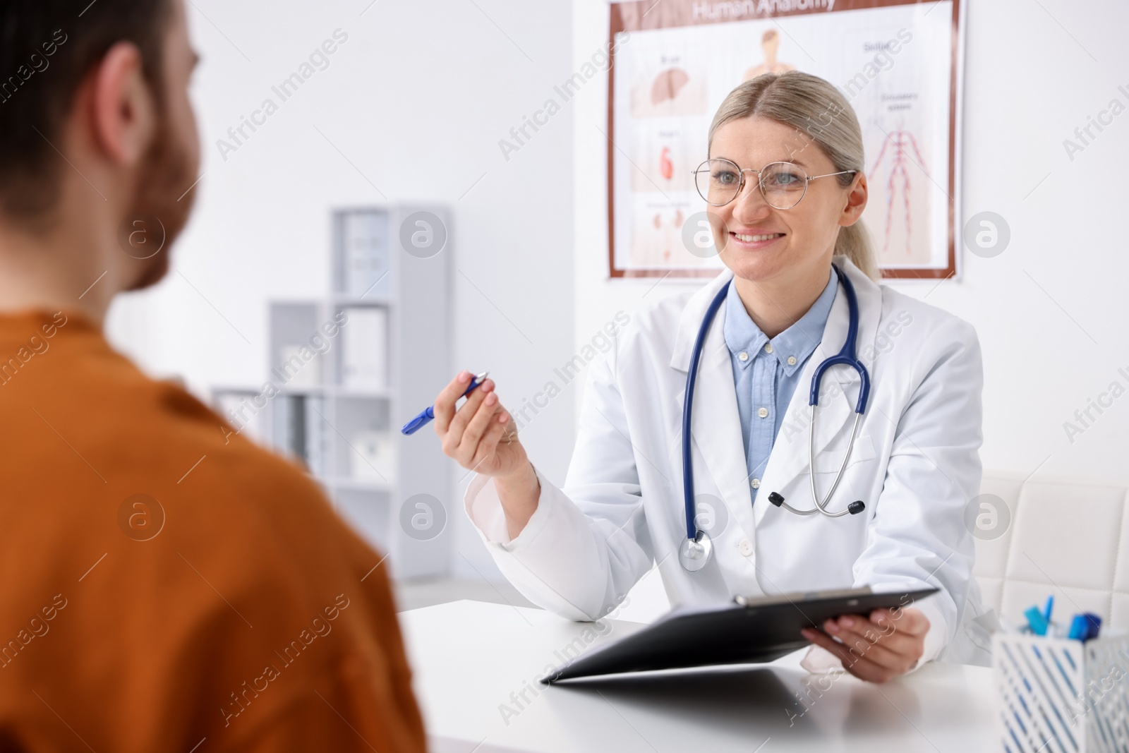 Photo of Doctor and her patient at desk in hospital