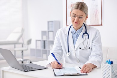 Photo of Professional doctor working at desk in hospital. Space for text