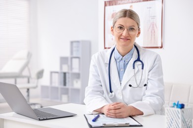 Photo of Professional doctor working at desk in hospital. Space for text