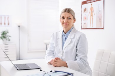 Photo of Professional doctor working at desk in hospital. Space for text