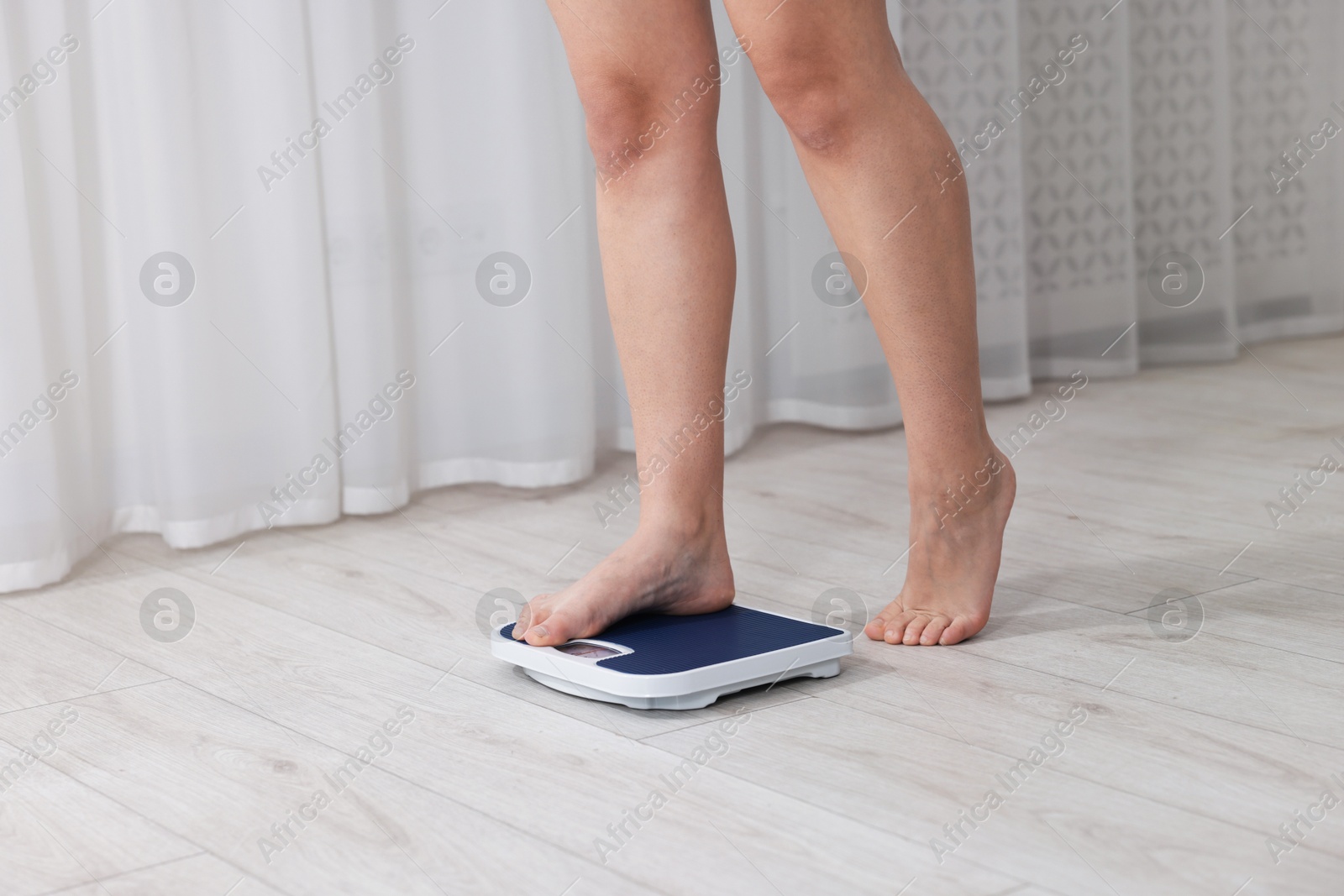 Photo of Woman on scales indoors, closeup. Weight loss