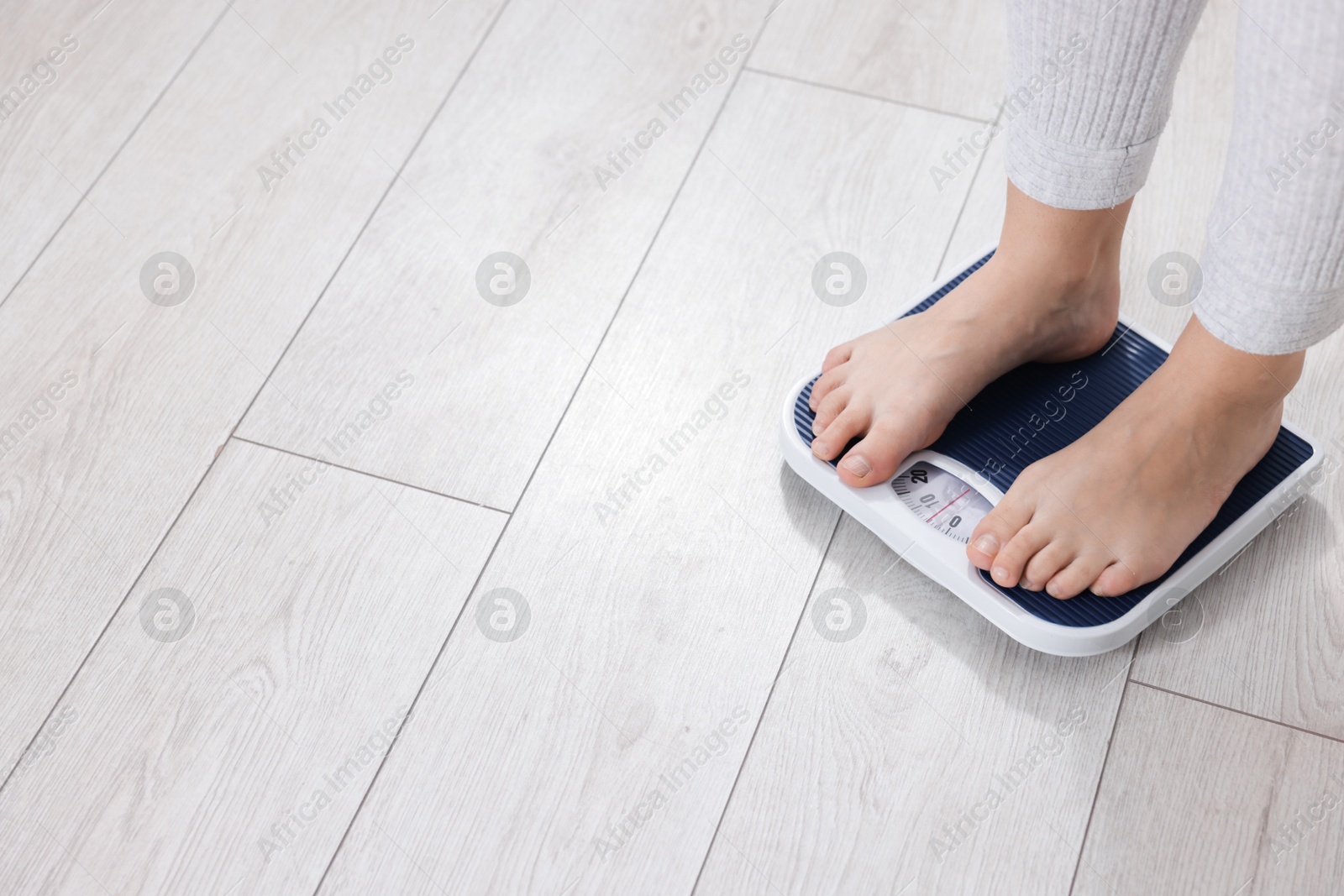 Photo of Woman on scales indoors, closeup with space for text. Weight loss