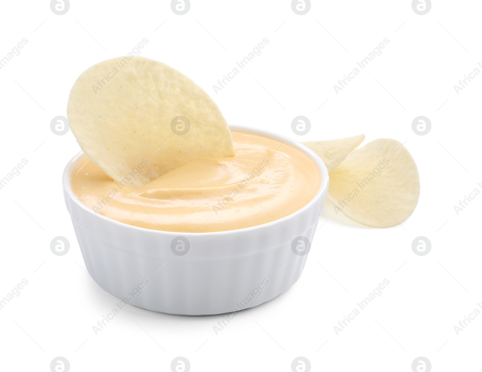 Tasty cheese dipping sauce in bowl and potato chips isolated on white Photo of Tasty cheese dipping sauce in bowl and potato chips isolated on white