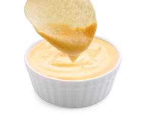 Photo of Dipping potato chip into tasty cheese sauce on white background, closeup
