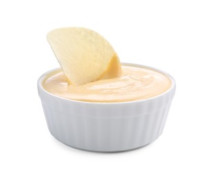 Photo of Tasty cheese dipping sauce in bowl and potato chip isolated on white