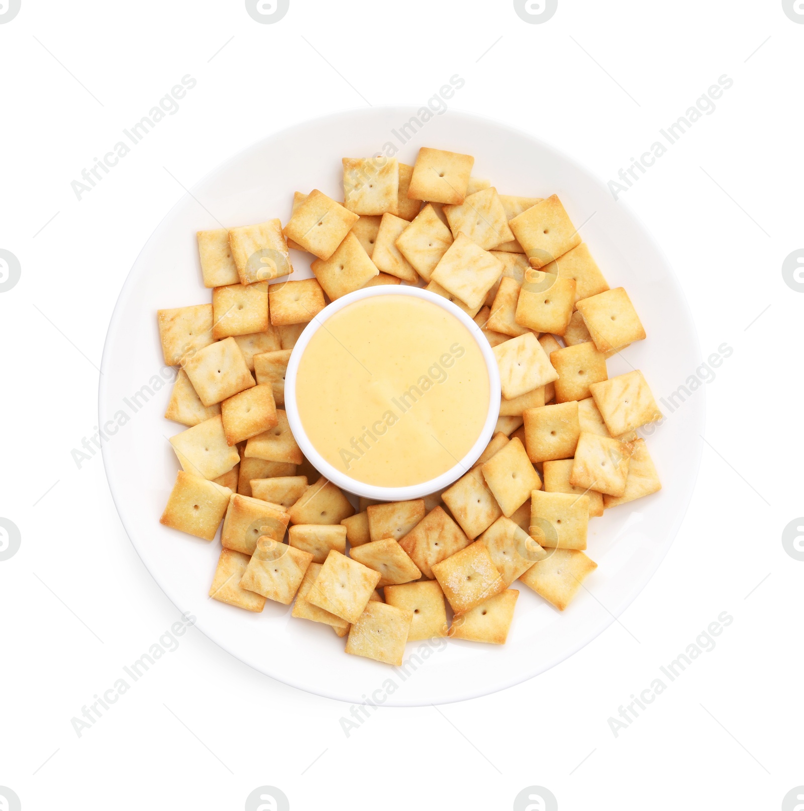 Photo of Tasty cheese dipping sauce in bowl and crackers isolated on white, top view
