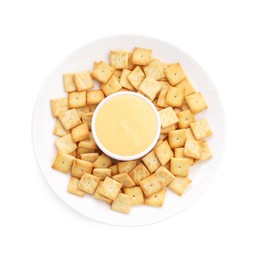 Photo of Tasty cheese dipping sauce in bowl and crackers isolated on white, top view
