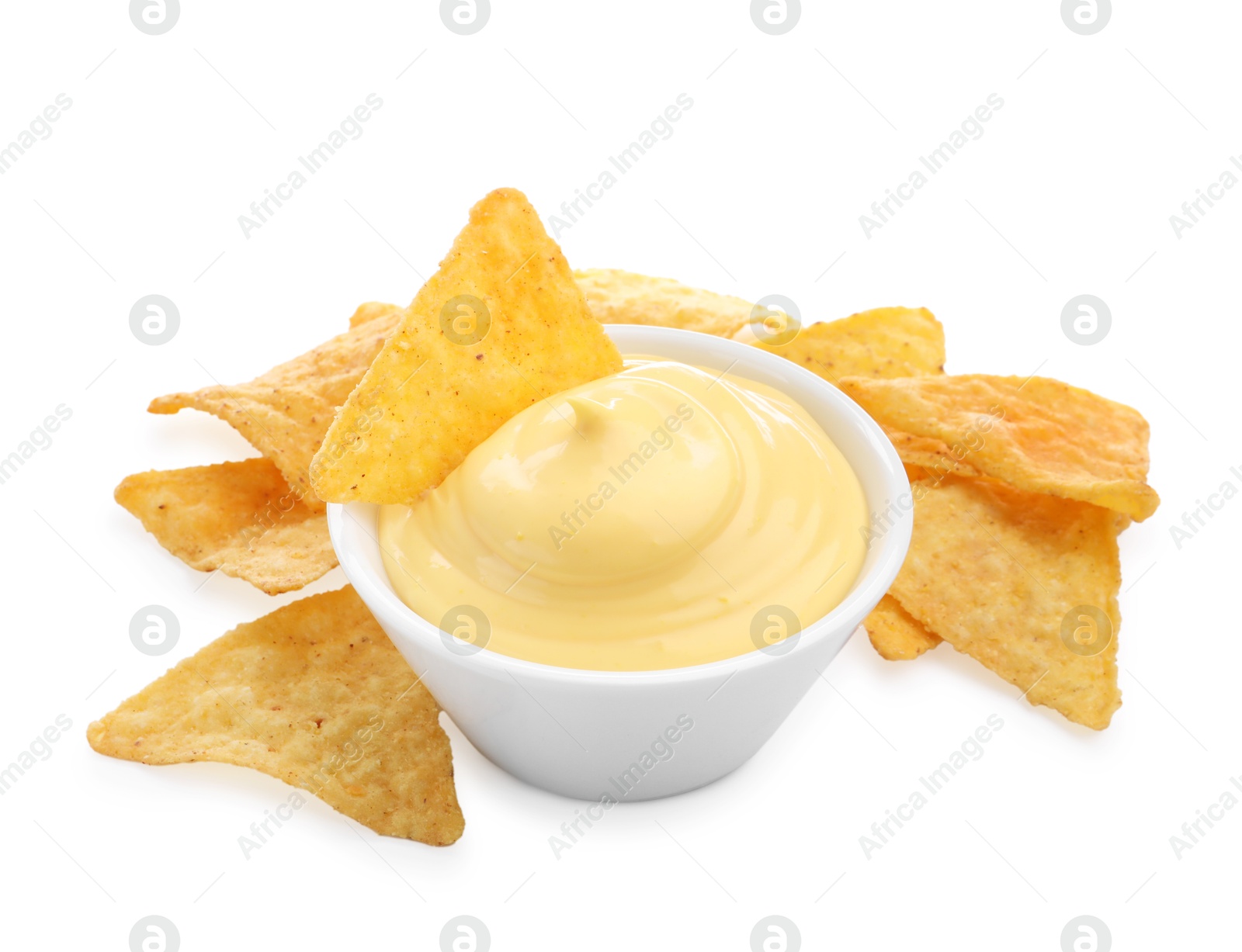 Photo of Tasty cheese dipping sauce in bowl and nacho chips isolated on white
