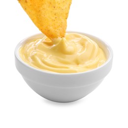 Photo of Dipping nacho chip into tasty cheese sauce on white background, closeup