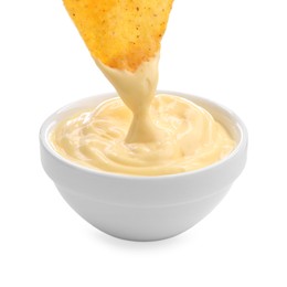 Photo of Dipping nacho chip into tasty cheese sauce on white background, closeup
