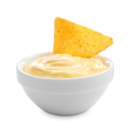 Photo of Tasty cheese dipping sauce in bowl and nacho chip isolated on white