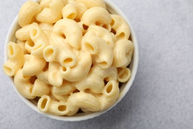 Photo of Delicious pasta with cheese sauce in bowl on grey table, top view