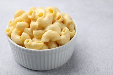 Photo of Delicious pasta with cheese sauce in bowl on grey table, closeup. Space for text