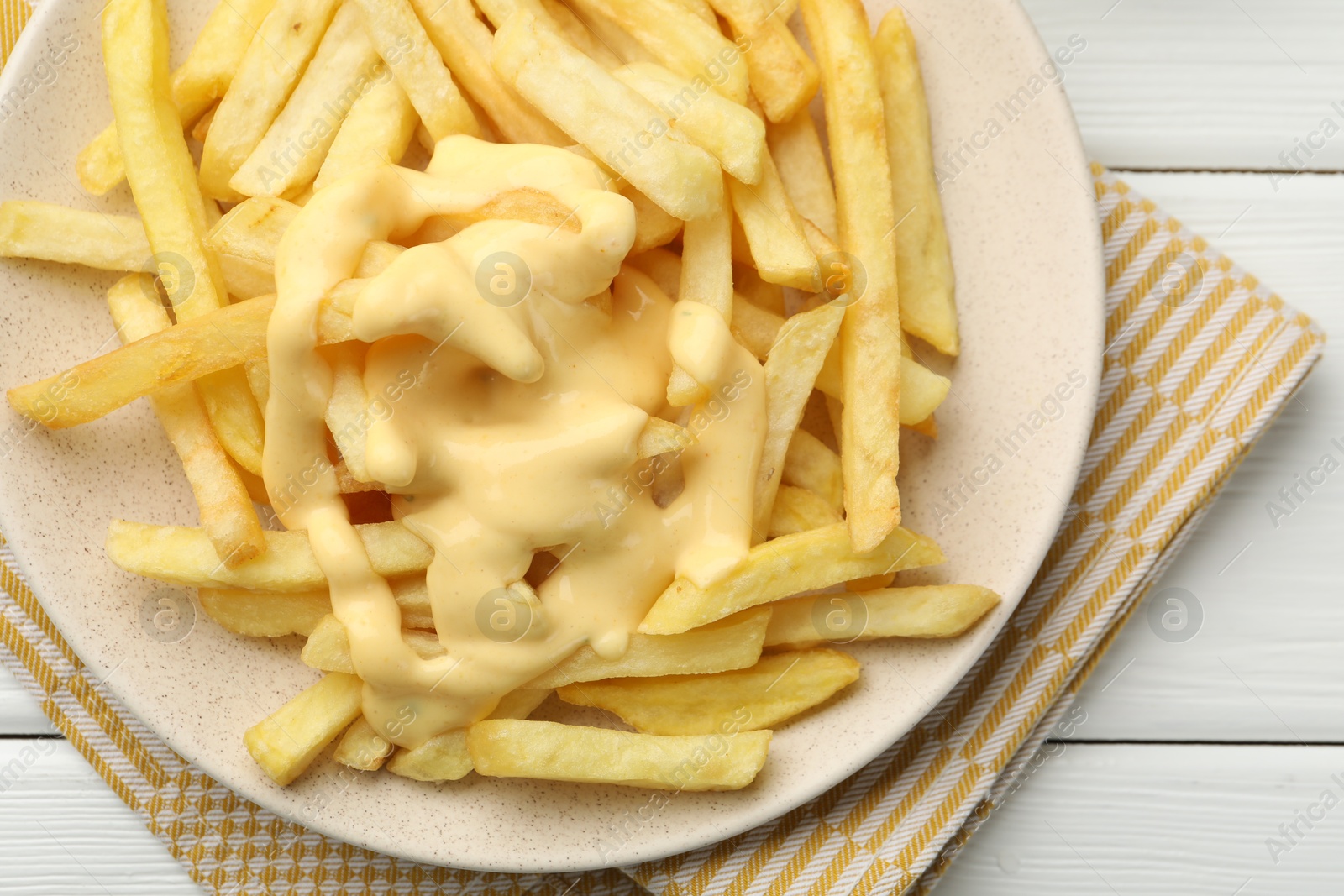 French fries with cheese sauce on white wooden table, top view Photo of French fries with cheese sauce on white wooden table, top view