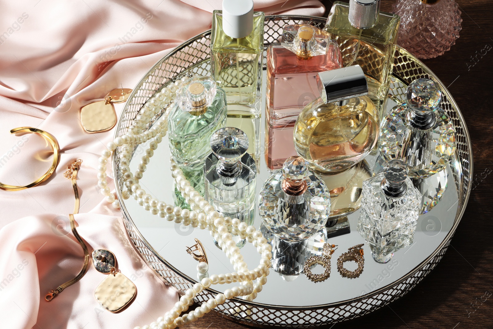 Different luxury perfumes and accessories on wooden table Photo of Different luxury perfumes and accessories on wooden table