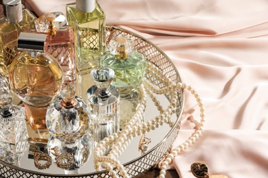 Photo of Different luxury perfumes and accessories on table, closeup