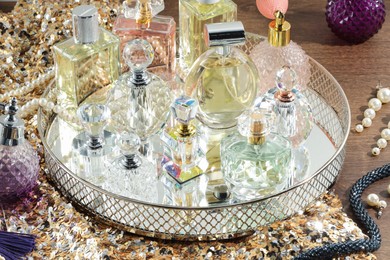 Photo of Different luxury perfumes and accessories on wooden table