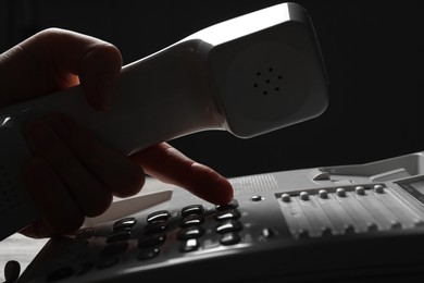 Photo of Woman dialing number on landline telephone, closeup