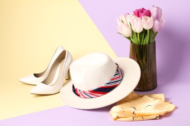 Photo of Hat with scarfs, heels and tulips on color background