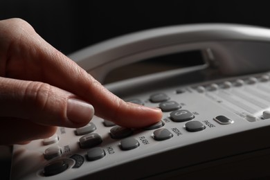 Photo of Woman dialing number on landline telephone, closeup