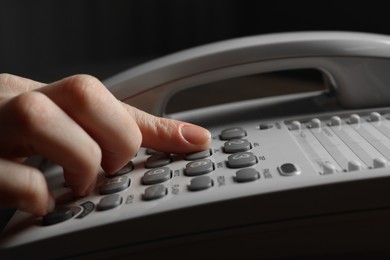 Photo of Woman dialing number on landline telephone, closeup