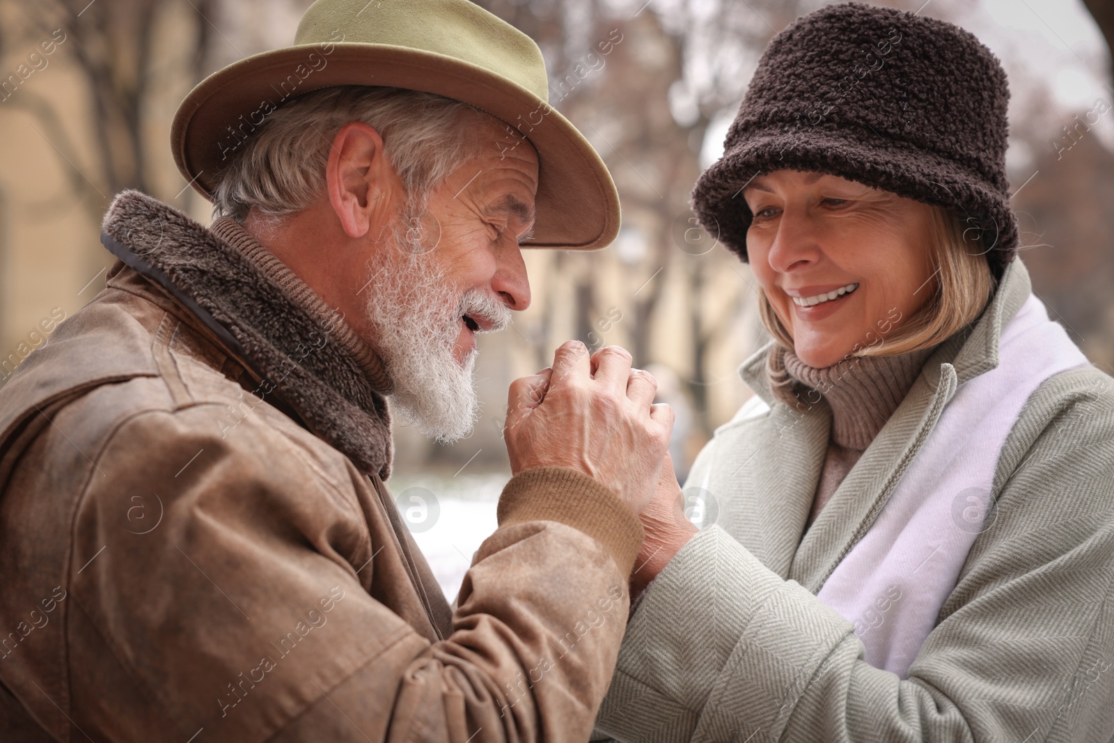 Photo of Lovely senior couple holding hands on winter day