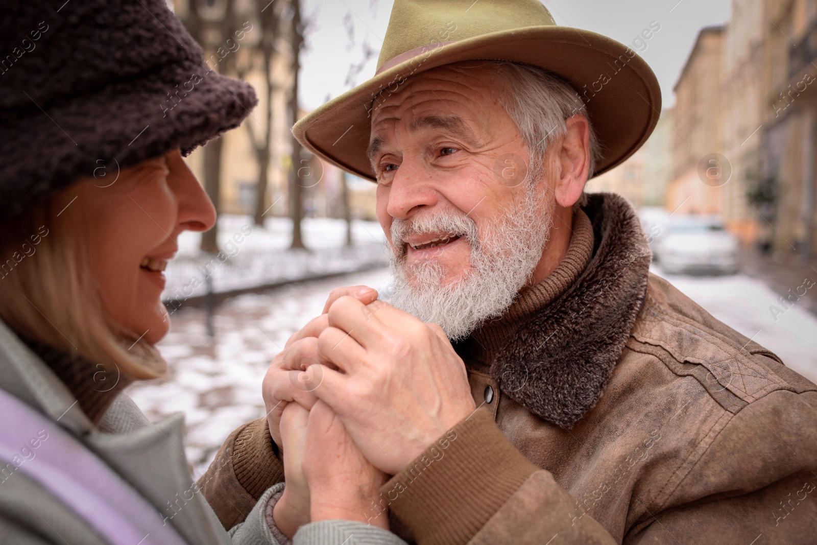 Photo of Happy senior couple holding hands on city street